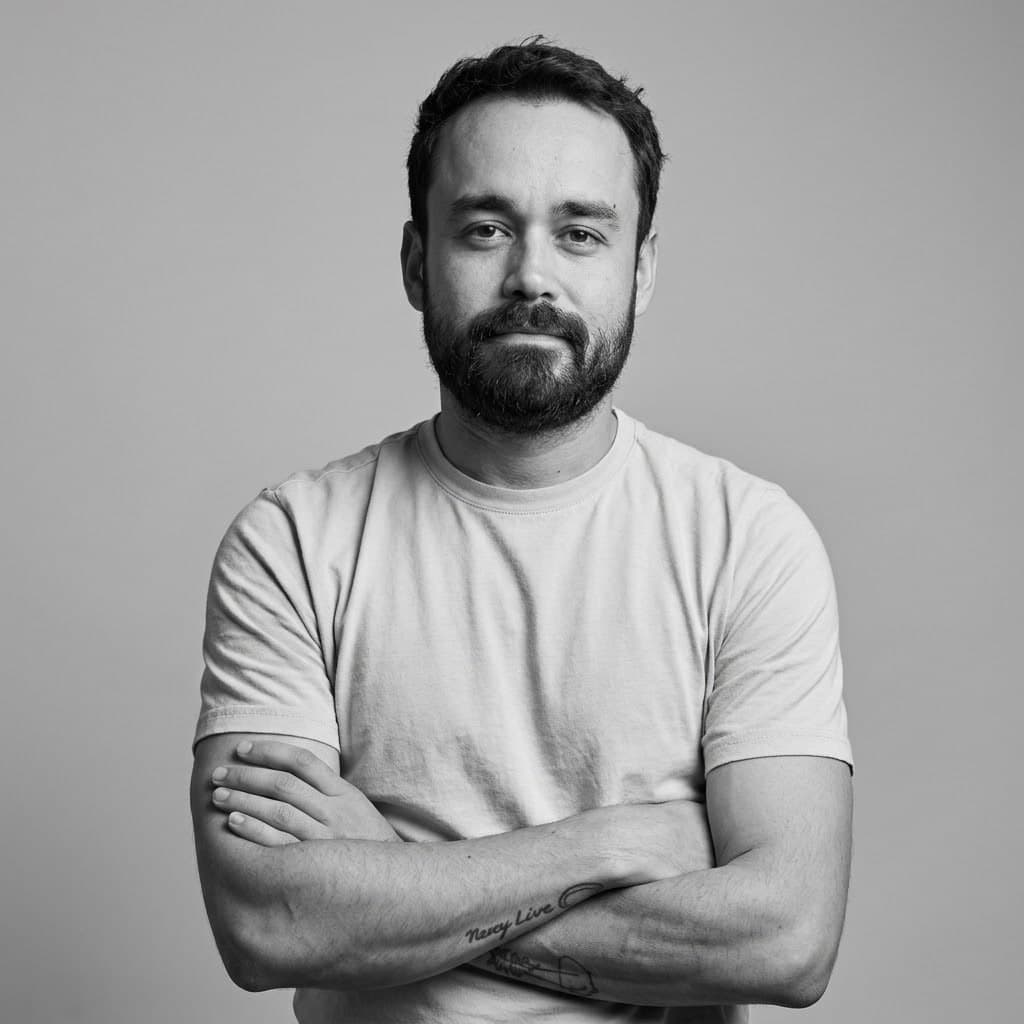 Black-and-white portrait of Santiago Valencia Vera, facing the camera with his arms crossed